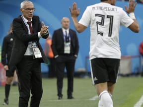 Egypt head coach Hector Cuper, left, clap hands towards Egypt's Trezeguet, right, during the group A match between Russia and Egypt at the 2018 soccer World Cup in the St. Petersburg stadium in St. Petersburg, Russia, Tuesday, June 19, 2018.