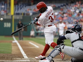 Philadelphia Phillies' Odubel Herrera, left, hits a three-run home run off St. Louis Cardinals starting pitcher Miles Mikolas during the first inning of a baseball game, Monday, June 18, 2018, in Philadelphia. Cardinals catcher Yadier Molina, right, looks on.