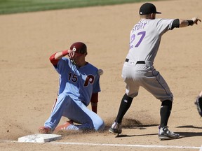 Philadelphia Phillies' Andrew Knapp, left, slides into third base past Colorado Rockies shortstop Trevor Story to advance on a ground out by Scott Kingery during the eighth inning of a baseball game, Thursday, June 14, 2018, in Philadelphia. Philadelphia won 9-3.