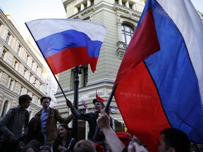 Russia fans wave national flags as fans from participating countries gathered on Nikolskaya Street to celebrate and to cheer on their teams, on the eve of the 2018 soccer World Cup, in Moscow, Russia, Wednesday, June 13, 2018.