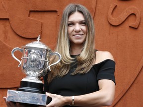 Romania's Simona Halep holds the cup at the Roland Garros stadium, Sunday, June 10, 2018 in Paris. Halep won Saturday the French Open tennis tournament women's final.