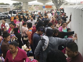 In this Monday, June 4, 2018 photo, people seeking political asylum in the United States line up to be interviewed in Tijuana, Mexico, just across the U.S. border south of San Diego. The Trump administration's fighting words for asylum seekers don't appear to be having much impact at U.S. border crossings with Mexico. Lines keep growing, so much that U.S. authorities can't take them all at once.