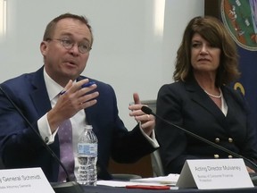 Mick Mulvaney, left, acting director of the federal Consumer Financial Protection Bureau, speaks during a panel discussion on elder abuse as Kathy Taylor, right, a senior vice president for the Kansas Bankers Association, listens, Friday, June 8, 2018, in Topeka, Kan. Mulvaney is considering ending online access to the bureau's complaint database.