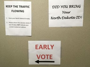 In this Tuesday June 5, 2018, photo, instructions are posted at an early voting precinct in Bismarck, N.D. North Dakota is the only state in the nation without voter registration, and casting one's ballot is a quick and relatively painless process that is prized by residents for its simplicity and uniqueness.