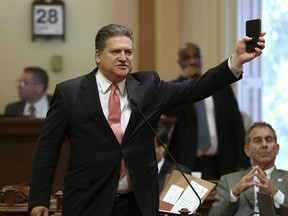 State Sen. Bob Hertzberg, D-Van Nuys, displays his smart phone as he urges lawmakers to approve a data privacy bill during the Senate floor session, Thursday, June 28, 2018, in Sacramento, Calif. Lawmakers approved the bill, that would let consumers ask companies to delete their information or refrain from selling it, among other data privacy provisions.