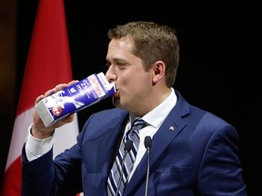 Conservative Leader Andrew Scheer drinks milk as he takes to the stage at the National Press Gallery Dinner in Gatineau, Que., on June 3, 2017.