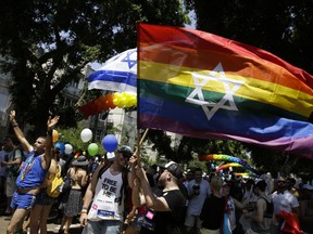 Israelis and tourists wave flags as they participate in the Gay Pride parade in Tel Aviv, Israel, Friday, June 8, 2018.