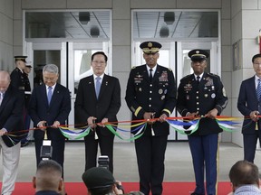 South Korean Defense Minister Song Young-moo, center left, and U.S. Gen. Vincent Brooks, center right, commander of the United Nations Command, U.S. Forces Korea and Combined Forces Command, cut tapes during an opening ceremony for the new headquarters of the U.S. Forces Korea (USFK) at Camp Humphreys in Pyeongtaek, South Korea. Friday, June 29, 2018.