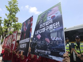 Members of People's Democratic Party hold up placards during a rally to oppose military exercises between the United States and South Korea near the U.S. embassy in Seoul, South Korea, Friday, June 15, 2018. U.S. President Donald Trump promised to end "war games" with South Korea, calling them provocative, after meeting North Korean leader Kim Jong Un earlier this week. The signs read " Stop Ulchi Freedom Guardian (UFG) exercises and withdrawal of U.S. troops."