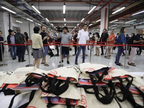 In this Sunday, June 10, 2018, photo, members of the press stand in line to collect their accreditation at the international media center in Singapore ahead of the summit between U.S. President Donald Trump and North Korean leader Kim Jong Un on June 12. The tiny city-state of Singapore is hosting its largest media contingent ever for Tuesday summit between President Donald Trump and North Korean leader Kim Jong Un.