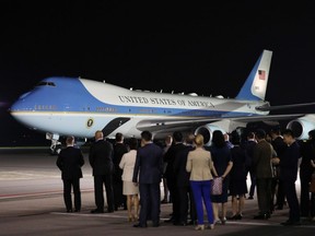 People wait for U.S. President Donald Trump to disembark from Air Force One at the Paya Lebar Air Base in Singapore, on Sunday, June 10, 2018.