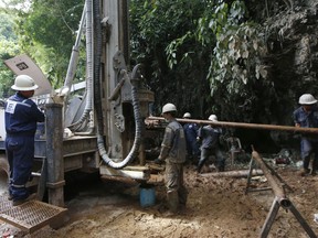 Workers operate a machinery in attempts to drain the water from a cave where 12 boys and their soccer coach have been missing, in Mae Sai, Chiang Rai province in northern Thailand, Friday, June 29, 2018. Floodwaters have reached near the entrance of the cave despite attempts to drain the water so rescuers can search farther into the complex.