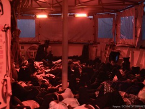 A handout picture taken on June 12, 2018 and released by the SOS Mediterranee NGO shows rescued migrants sleeping aboard the French NGO's ship Aquarius, in the search and rescue zone in the Mediterranean sea.  Hundreds of migrants stranded on a rescue vessel in the Mediterranean will be taken to Spain with the help of two Italian ships, a charity said on June 12, 2018, after deteriorating weather conditions sparked fears for their safety.