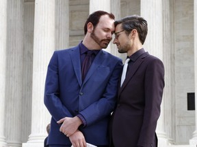 In this Dec. 5, 2017 file photo, Charlie Craig, left, and David Mullins touch foreheads after leaving the Supreme Court in Washington. The Supreme Court is setting aside a Colorado court ruling against a baker who wouldn't make a wedding cake for the same-sex couple. But the court is not deciding the big issue in the case — whether a business can refuse to serve gay and lesbian people.