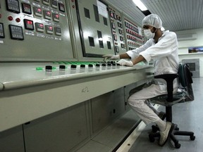 FILE - In this Feb. 3, 2007 file photo, an Iranian technician works at the Uranium Conversion Facility just outside the city of Isfahan, Iran, 255 miles (410 kilometers) south of the capital Tehran. Iran says it restarted the production facility in Isfahan, a "major" uranium facility involved in its nuclear program, but still pledges to follow the terms of its atomic deal now threatened by President Donald Trump pulling America from the accord.
