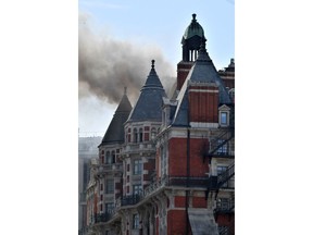 Smoke rises after a fire broke out in Knightsbridge, central London Wednesday June 6, 2018. London Fire Brigade says about 100 firefighters are tackling a blaze at a luxury hotel. Video footage shows smoke billowing from the roof of the Mandarin Oriental Hotel in London's ritzy Knightsbridge area.