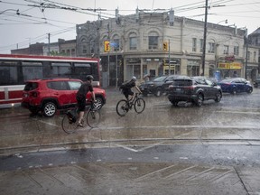 Cyclists make there way through Toronto during a thunderstorm on Wednesday, June 13, 2018. Much of southern Ontario was under severe thunderstorm watches and warnings on Wednesday afternoon and electrical utility Hydro One said about 47,000 customers were without power, many due to storm-related outages.