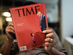 An AFP journalists reads a copy of Time Magazine with a front cover using a combination of pictures showing a crying child taken at the US Border Mexico and a picture of US President Donald Trump looking down, on June 22, 2018 in Washington DC.