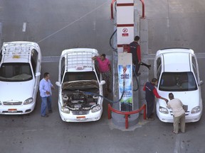 FILE - In this June 29, 2017, file photo, taxi drivers chat as they refuel their vehicles at a gas station in Cairo, Egypt. Egypt announced Saturday, June 16, 2018 steep increases in fuel and cooking gas prices as part of the country's economic reforms and austerity measures designed to overhaul the country's ailing economy.