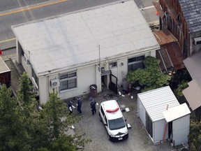 Investigators work at a police station in Toyama, northwest of Tokyo Tuesday, June 26, 2018. Police say a knife-wielding man slashed and killed an officer in the local police station, took the man's gun and fatally shot a security guard outside a nearby elementary school. (Kyodo News via AP)