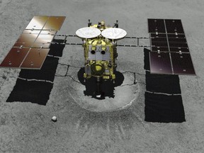 This computer graphics image provided by the Japan Aerospace Exploration Agency (JAXA)  shows asteroid explorer Hayabusa2 landing on a crater that it made.