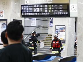 Firefighters are seen at Odawara station as a Japan's bullet train made an unscheduled stop due to a knifing attack in Odawara, Japan, late Saturday, June 9, 2018. A knifing spree on a Japanese express train near Tokyo has left one passenger dead and two others injured. (Kyodo News via AP)