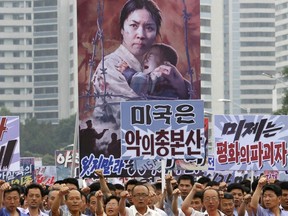 FILE - In this June 25, 2017, file photo, tens of thousands of men and women pump their fists in the air and chant as they carry placards with anti-American propaganda slogans at Pyongyang's central Kim Il Sung Square, in North Korea, to mark what North Korea calls "the day of struggle against U.S. imperialism" – the anniversary of the start of the Korean War. In another sign of detente following the summit between North Korean leader Kim Jong Un and U.S. President Donald Trump, North Korea has opted not to hold this year's "anti-U.S. imperialism" rally.
