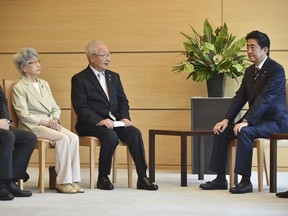 Japanese Prime Minister Shinzo Abe, right, listens to Shigeo Iizuka, third from left, leader of a group of families of Japanese abducted by North Korea, and Sakie Yokota, second from left, mother of Megumi Yokota, one of the Japanese abductees, during a meeting at his official residence in Tokyo Thursday, June 14, 2018.