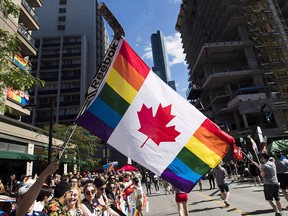 A man waves a flag from a hockey stick during the Pride parade in Toronto on June 25, 2017.
