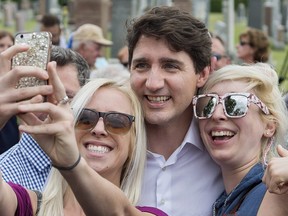 Prime Minister Justin Trudeau poses with members of the public during a visit to a Saint-Jean Baptiste day celebration in Vaudreuil-Dorion, Que., Sunday, June 24, 2018.