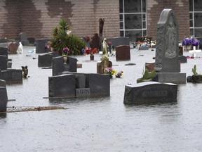 In this Tuesday, June 19, 2018 photo, gravestones in Calvary Cemetery are submerged in floodwaters during a rain storm in Port Arthur, Texas. Parts of Corpus Christi and the Beaumont-Port Arthur area have flooded after receiving several inches of rain and emergency personnel Wednesday were on the lookout for more precipitation.