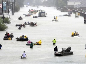 FILE - In this Aug. 28, 2017, file photo, rescue boats fill a flooded street as flood victims are evacuated as floodwaters from Tropical Storm Harvey rise in Houston. A new report on the damage caused by Hurricane Harvey says the U.S. has never experienced the amount of rainfall across such a vast area as that brought by Harvey when it struck Texas. The report released this week by the Harris County Flood Control District says more rain fell over a five-day period, and on such a broad area, than at any time since records have been kept.