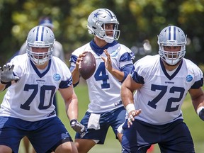 Dallas Cowboys quarterback Dak Prescott (4) throws a pass behind offensive guard Zack Martin (70) and center Travis Frederick (72)  during NFL football minicamp Wednesday, June 13, 2018, in Frisco, Texas.