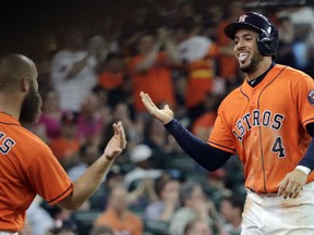 Houston Astros' George Springer (4) celebrates with Evan Gattis (11) after scoring against the Boston Red Sox during the first inning of a baseball game Friday, June 1, 2018, in Houston.