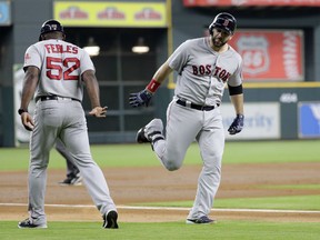 Boston Red Sox's Mitch Moreland, right, is congratulated by third base coach Carlos Febles (52) after hitting a two-run home run against the Houston Astros during the first inning of a baseball game Sunday, June 3, 2018, in Houston.