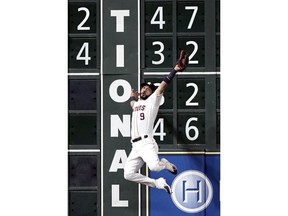 Houston Astros left fielder Marwin Gonzalez leaps at the wall to make the catch of a fly ball by Boston Red Sox's Andrew Benintendi during the third inning of a baseball game Saturday, June 2, 2018, in Houston.