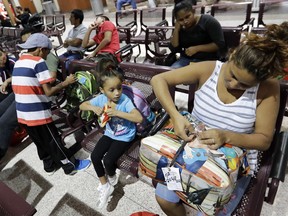 Immigrant Elyse Hernandez, from Honduras, right, waits with her daughter Genesis, center, and son, Jorge David, left, inside the bus station Saturday, June 23, 2018, in McAllen, Texas. The family slept on a bridge for three days before entering the United States.