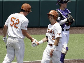 Texas' Kody Clemens (2) celebrates with teammate Zach Zubia (52) after he hit a solo home run against Tennessee Tech pitcher Alex Hursey in the third inning of an NCAA college super regional baseball game, Monday, June 11, 2018, in Austin, Texas.