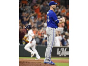 Toronto Blue Jays starting pitcher J.A. Happ, right, looks away as Houston Astros' Alex Bregman, back left, rounds the bases after hitting a solo home run during the third inning of a baseball game, Monday, June 25, 2018, in Houston.