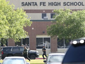 FILE - In this May 18, 2018, file photo, law enforcement officers respond to Santa Fe High School after an active shooter was reported on campus in Santa Fe, Texas. The school district where eight students and two teachers were fatally shot has implemented security measures increasing the number of police officers and guards on campuses. The Santa Fe Independent School District said the increased security presence began Wednesday, June 6, 2018, at the district's four schools southeast of Houston.