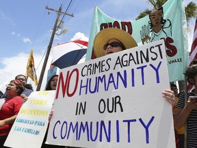 Stefanie Herweck stands with other protesters in front of the U.S. Customs and Border Protection's Rio Grande Valley Sector's Centralized Processing Center on Sunday, June 17, 2018, in McAllen, Texas. The U.S. Border Patrol on Sunday allowed reporters to briefly visit the facility where it holds families arrested at the southern U.S. border, responding to new criticism and protests over the Trump administration's "zero tolerance" policy and resulting separation of families.