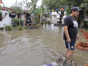 Alfredo Trevino, owner of Nana's Tacos, walks through water in front of his restaurant after heavy rains caused water to rise and flood whole neighborhoods, Thursday, June 21, 2018, in Weslaco, Texas.