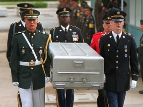 In this May 14, 1999, file photo, U.N. honor guards carry a coffin containing the remains of the American soldiers after it was returned from North Korea at the border village of Panmunjom, South Korea.