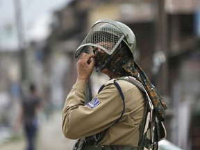 FILE- In this May 17, 2018 file photo, an Indian paramilitary soldier stands guard on a road during the first day of the holy month of Ramadan in Srinagar, Indian controlled Kashmir. The U.N. human rights chief is calling for a commission of inquiry to conduct an independent, international investigation into alleged rights violations in Kashmir.