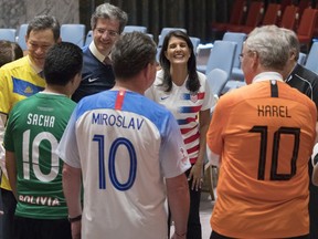 American Ambassador to the United Nations Nikki Haley, center, speaks to other members of the Security Council before posing for a photo wearing the jerseys of their country's soccer teams, Thursday, June 14, 2018, at United Nations headquarters. Russian Ambassador to the United Nations Vassily Nebenzia, who is the current president of the Security Council, organized the photo op in honor of the first day of the World Cup Soccer championship.