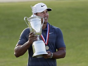 Brooks Koepka holds up the Golf Champion Trophy after winning the U.S. Open Golf Championship, Sunday, June 17, 2018, in Southampton, N.Y.