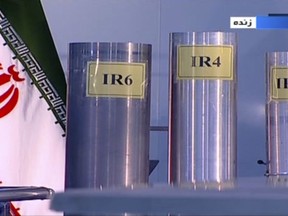 In this June 6, 2018 frame grab from Islamic Republic Iran Broadcasting, IRIB, state-run TV, three versions of domestically-built centrifuges are shown in a live TV program from Natanz, an Iranian uranium enrichment plant, in Iran. The program from made a point to show the centrifuges labeled in English in the background. Those shown Wednesday night are more-sophisticated devices Tehran is currently prohibited from running under the nuclear deal with world powers. (IRIB via AP)