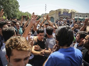 A group of protesters chant slogans at the main gate of old grand bazaar in Tehran, Iran, Monday, June 25, 2018. Protesters in the Iranian capital swarmed its historic Grand Bazaar on Monday, news agencies reported, and forced shopkeepers to close their stalls in apparent anger over the Islamic Republic's troubled economy, months after similar demonstrations rocked the country. (Iranian Labor News Agency via AP)