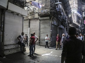 People stand in the old grand bazaar where shops are closed after a protest, in Tehran, Iran, Monday, June 25, 2018. Protesters in the Iranian capital swarmed its historic Grand Bazaar on Monday, news agencies reported, and forced shopkeepers to close their stalls in apparent anger over the Islamic Republic's troubled economy, months after similar demonstrations rocked the country. (Iranian Labor News Agency via AP)