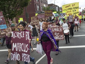 Marchers, including Jessica Moreno, center, shout, "Justice for Marcus", as they head to Richmond Police Headquarters from VCU's Siegel Center in Richmond, Va, on Saturday, June 2, 2018. Twenty-four-year-old Marcus-David Peters was shot and killed May 14 by a Richmond police officer after a confrontation on Interstate 95. Peters was unarmed but charged at the officer, who first fired a stun gun and then his service weapon.